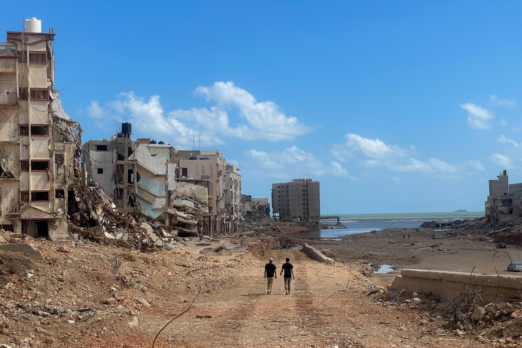 Two people walk through the destruction caused by the Daniel storm in Libya.