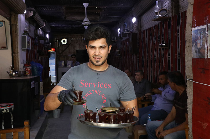 Lien vers le site du PNUD Un cafetier tient un plateau de café dans ses mains