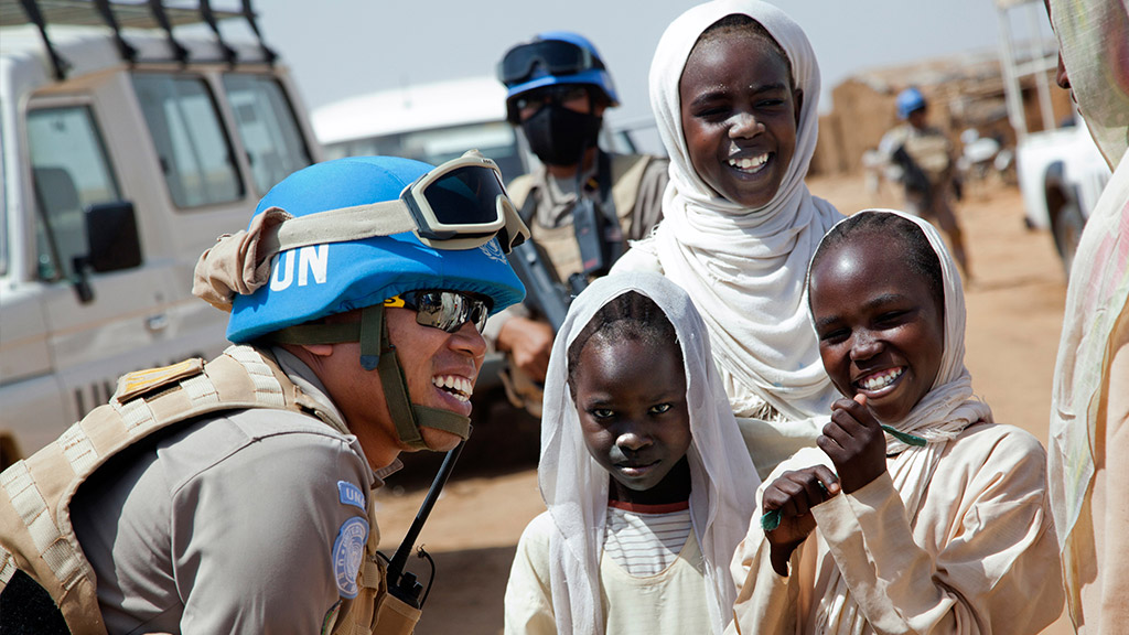 El teniente coronel Yenni Windarti, pacificador de la UNAMID, de la policía civil de Indonesia, interactúa con mujeres y niños en un punto de agua en el campamento de Abu Shouk para personas internamente desplazadas (Darfur del Norte) durante una patrulla matutina. Foto UNAMID/Albert González Farran